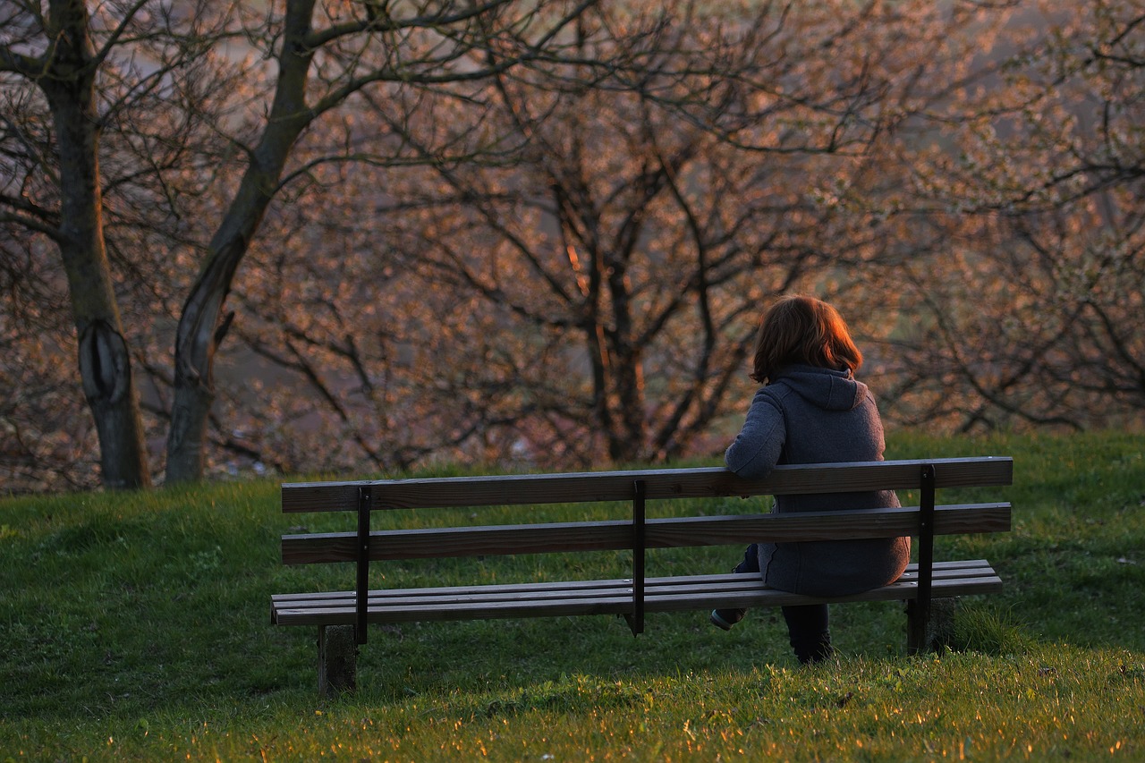 A woman sitting on a bench enjoying nature